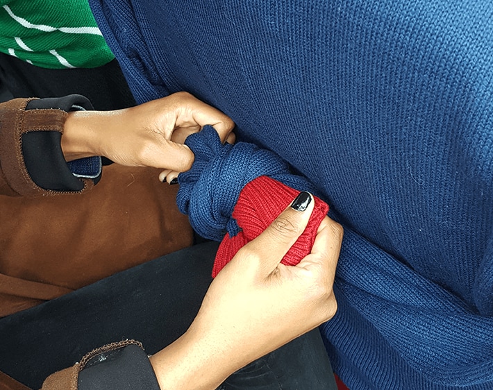 Pull arms to the back of the seat and tie in a knot