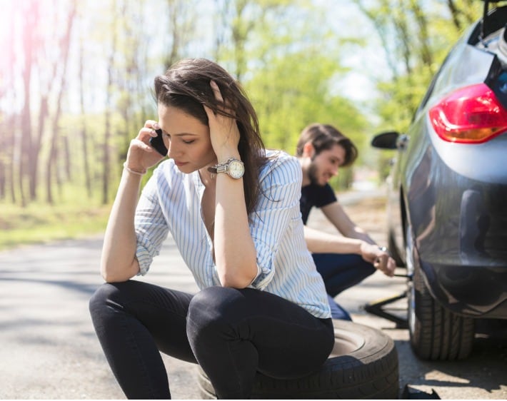 young-couple-flat-tire-on-the-road-picture-id669544446