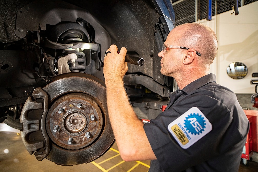 mechanic inspecting car brakes