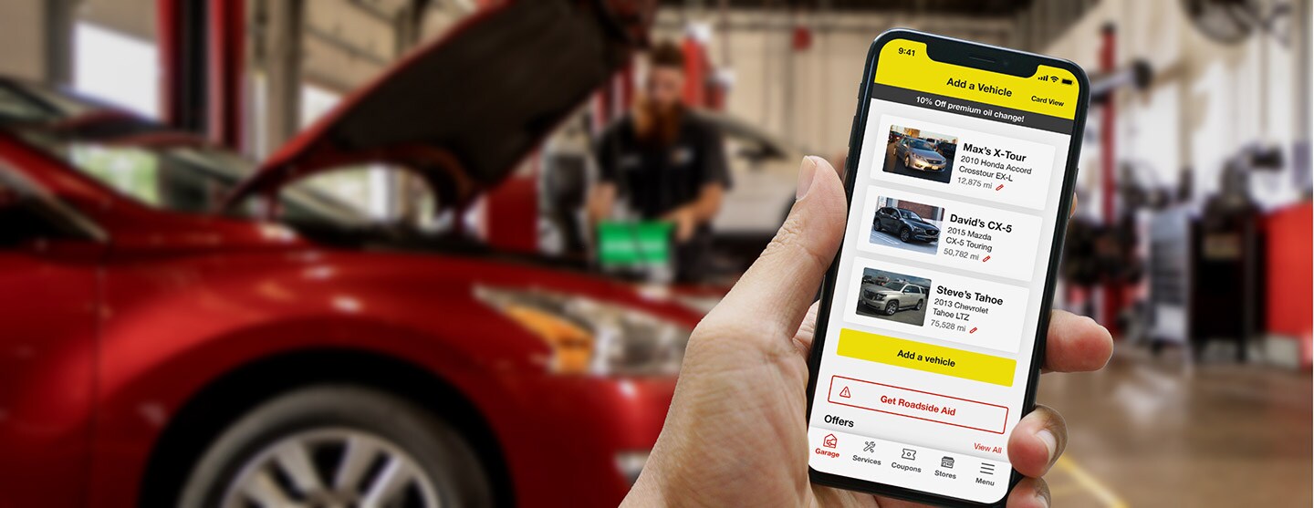 Hand holding mobile device showing Tires Plus mobile app